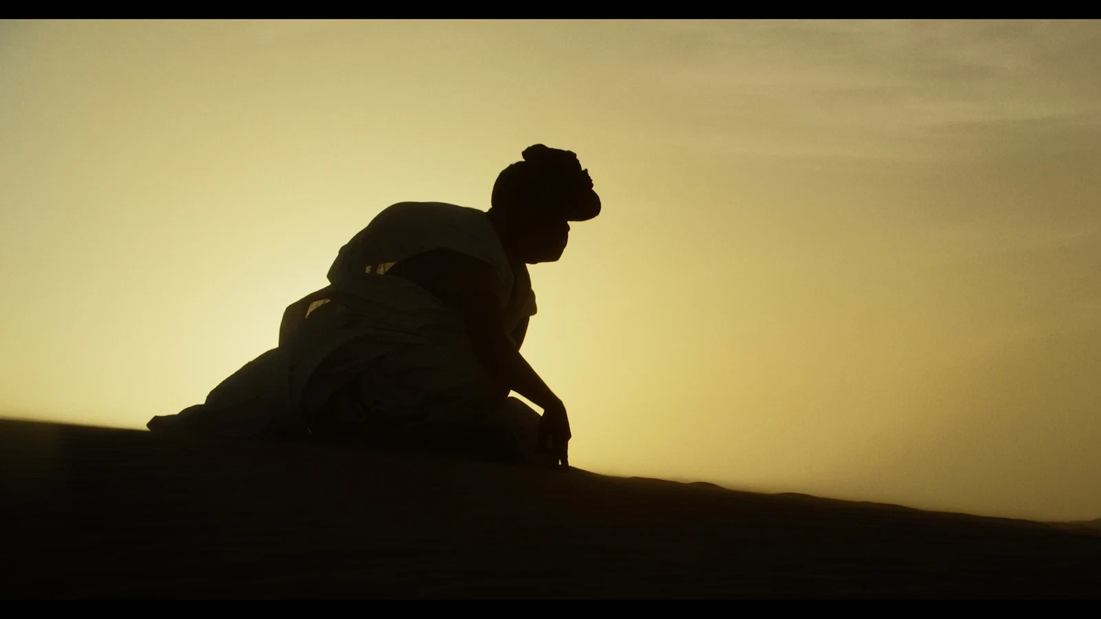 Silhouette of a musician in warm Saharan light from Poetry and Music of the Sahara